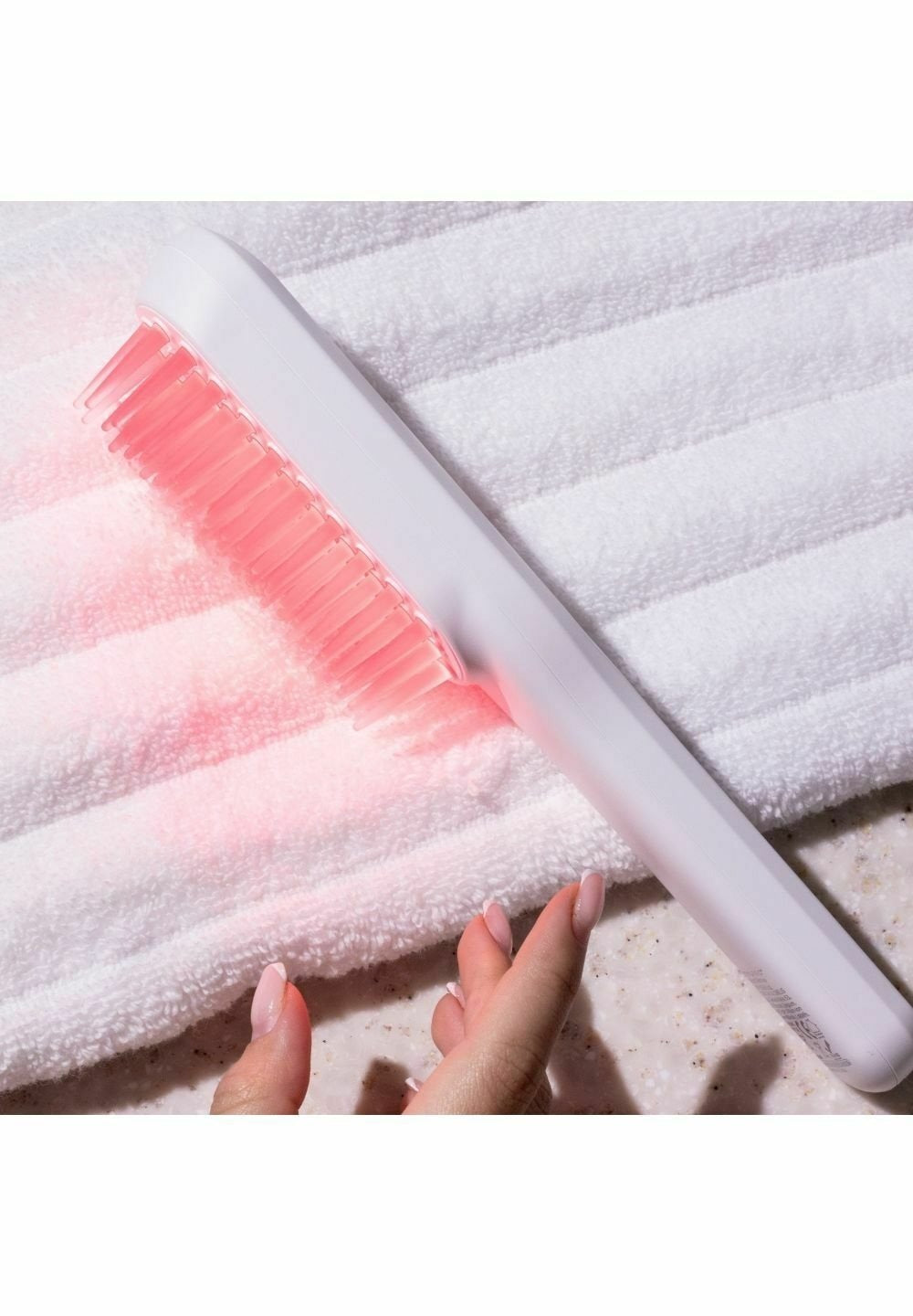 Brosse LED allumée posée sur une serviette
